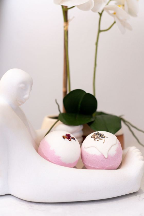 Pink bath bombs in a white ceramic dish