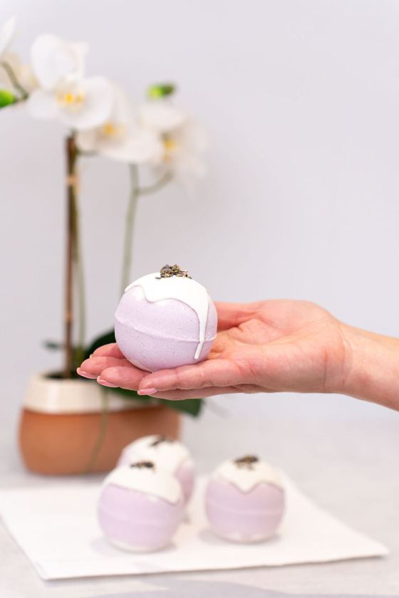 Holding out a lilac bath bomb