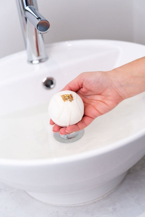 Gold-leaf bath bomb over the water